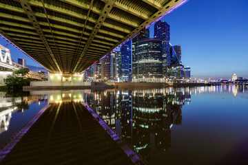 bottom view of the bridge on high-rise buildings with beautiful lights in the evening