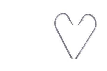 Two fishing hooks isolated on a white background close-up. Heart fishing hooks macro photo. Love for fishing.