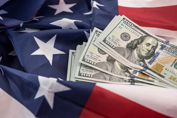 Stacks of the  one hundred dollar bill lying on american flag
