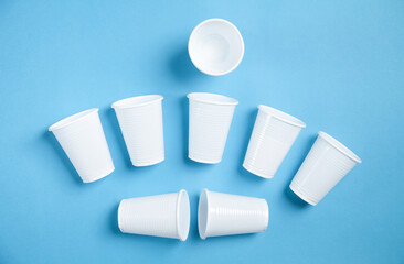 White transparent disposable plastic cups on the blue background.