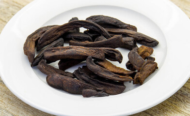 Burnt french fries isolated on a white plate - conceptual image in horizontal format