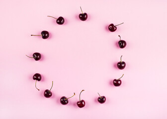Cherry circle pattern frame on pink background. Flat lay