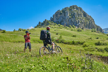 two men on mountain bikes one takes photos the other