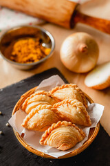 Curry puff on a dark plate and ingredients