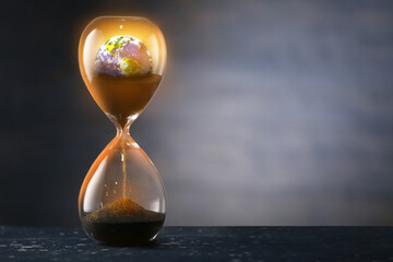 Hourglass with crumbling Earth on dark background. Concept of time