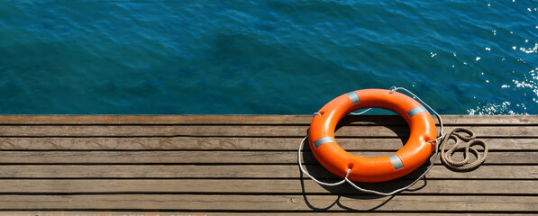 Lifebuoy ring on sea pier with space for text - obrazy, fototapety, plakaty