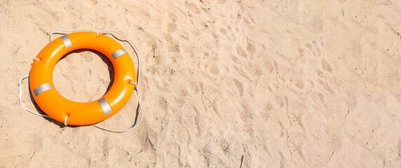 Lifebuoy ring on sand with space for text