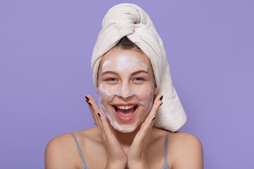Girl wearing hydro gel mask, using facial mask for skin treatment, looks happy and excited, keeping...