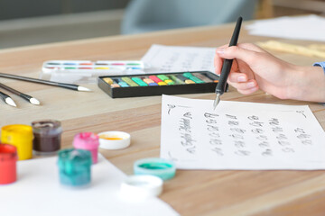 Female calligraphist working in office, closeup