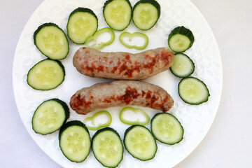 Fried sausages with slices of fresh cucumbers