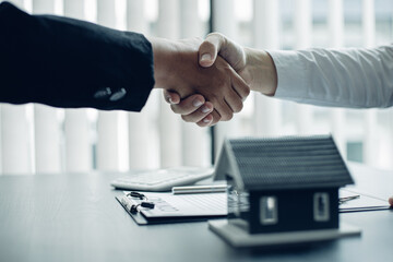 Asian men and women join hands after completing house purchase contract