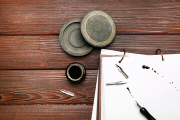 Obraz na płótnie Canvas Notebook, nib pen and ink on table
