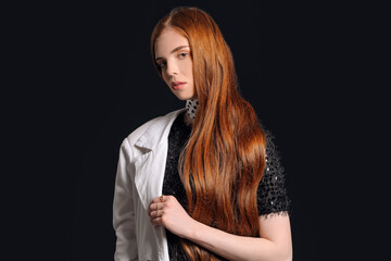 Naklejka premium Beautiful young redhead woman on dark background