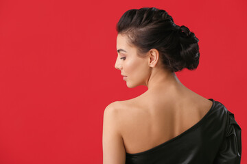 Obraz premium Beautiful young woman with stylish hairdo on color background, back view