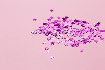 Closeup asterisks sprinkled on a pink isolated background. View from above.