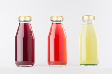 Red, pink, green fruit juices collection in glass bottles with cap in row mock up on white background, template for packaging, advertising, design product, branding.