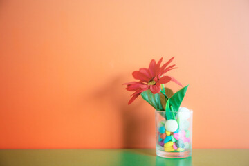 Flowers in a glass of water at wall.