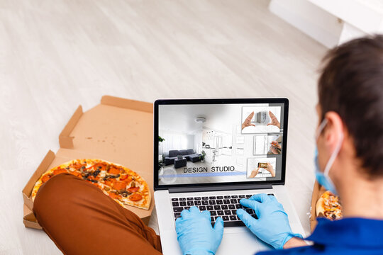Man in medical mask and rubber gloves sits at home on a table and works with laptop during quarantine. Designer, artist, architect, businessman at remote work in a pandemic covid. Coronavirus.