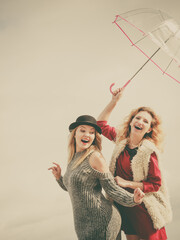 Two fashionable women and umbrella