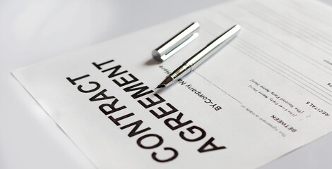 Pen on the contract agreement papers on white background