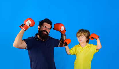 Parenthood relationship. Little boy sportsman at boxing training with coach on boxing ring. Sportswear fashion. Ready for sparring. Bearded sports man coaching boxing little boy in red boxing gloves.