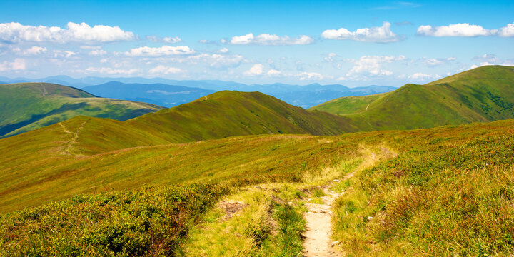 trail uphill through mountain range. grass on the hills and slopes. summer landscape on a sunny day.