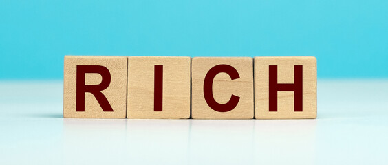 Word RICH made with cube wooden block