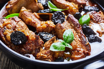 Pork ribs stew with prunes, broth, and red wine