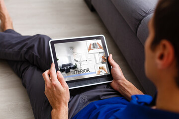 Creative businessman writing on graphic tablet while using laptop in office