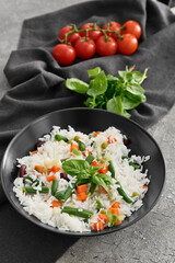 Bowl with tasty rice, beans and vegetables on grunge background