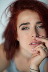 Beautiful young ginger woman with freckles and blue eyes. Portrait of charming girl wearing casual clothes posing at home, looking at camera