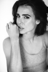 Beautiful young ginger woman with freckles. Black and white portrait of charming girl wearing...