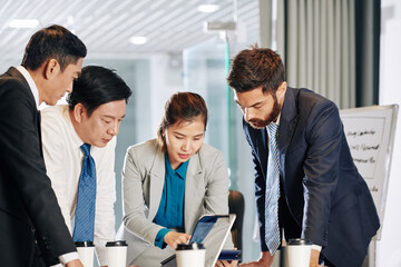 Multi-ethnic business team gathered at office table to discuss project