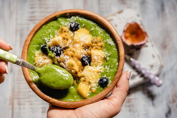 Green smoothie bowl with tropical fruits and kale