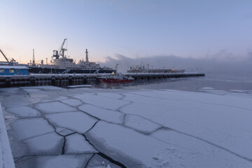 Berth, ships, ice floes in the seaport in winter.