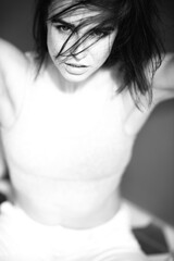 Beautiful young ginger woman with freckles. Black and white portrait of charming girl wearing...