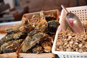 Fresh oysters and shells sale on outdoor market in Sicily, soft focus. Restaurant delicacy. Saltwater oysters