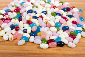 Varicolored jelly beans on the wooden surface close-up