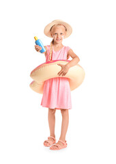 Little girl with sun protection cream and inflatable ring on white background