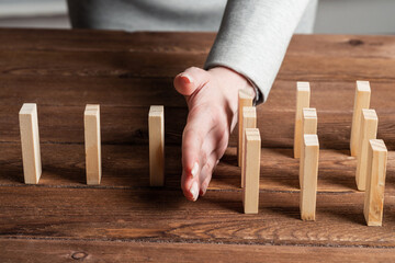 Business woman hand stop domino effect