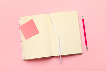 Stylish notebook with pencil on color background
