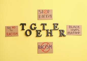 Different placards with text TOGETHER on color background. Stop racism