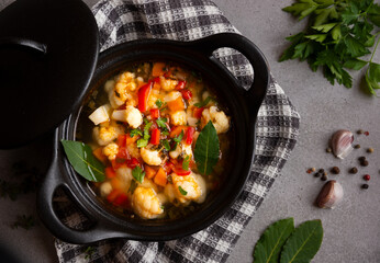 Vegetable soup with cauliflower, laurel and other vegetables in cooking pot