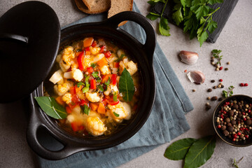 Vegetable soup with cauliflower, laurel and other vegetables in cooking pot