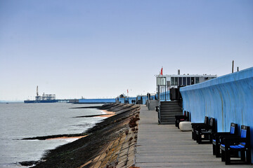 Fototapeta premium Benches by the sea wall at Concord beach Canvey Island, Essex, England