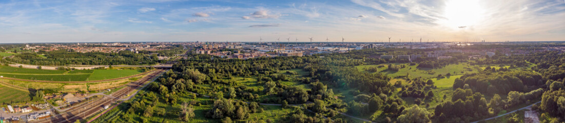 Aerial sunset view on Antwerp North area, with city and harbor in far distance, nature park oude landen in foreground