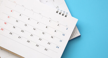 calendar page close up on blue background business planning appointment meeting concept - obrazy, fototapety, plakaty