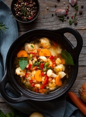 Vegetable soup with cauliflower, laurel and other vegetables in cooking pot