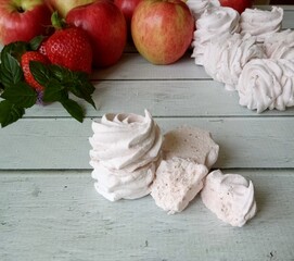  marshmallow, apple and strawberry on white wooden desk