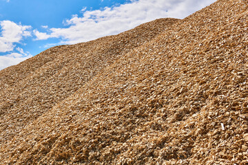 huge pile of wood chips against the sky